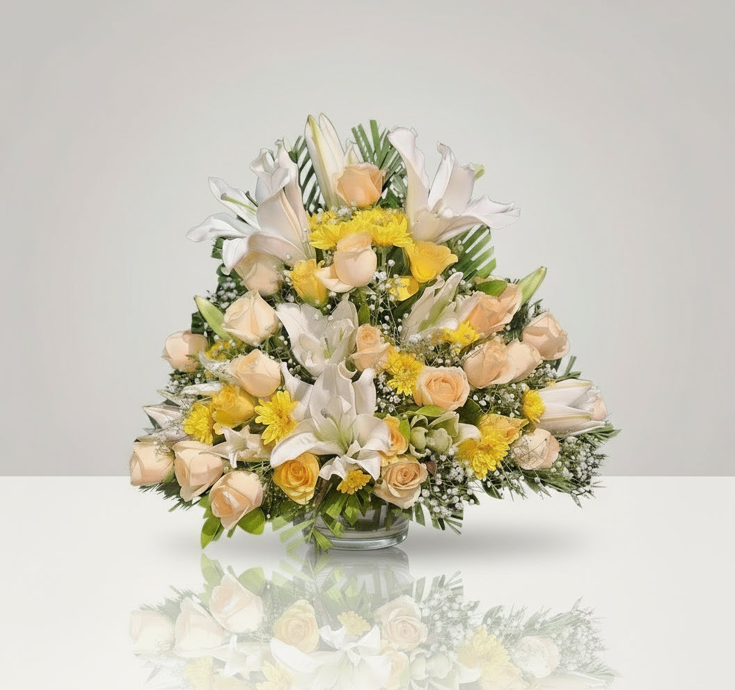 A stunning floral arrangement featuring white lilies, yellow roses, peach roses, and yellow daisies with fillers. This vibrant bouquet symbolizes beauty, love, and joy, making it an ideal gift for any occasion.