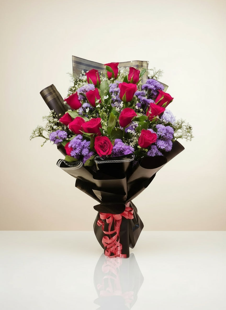 A captivating black bouquet featuring vibrant purple daisies, rich red roses, and delicate fillers. This elegant and sophisticated floral arrangement makes the perfect gift for expressing love and admiration.