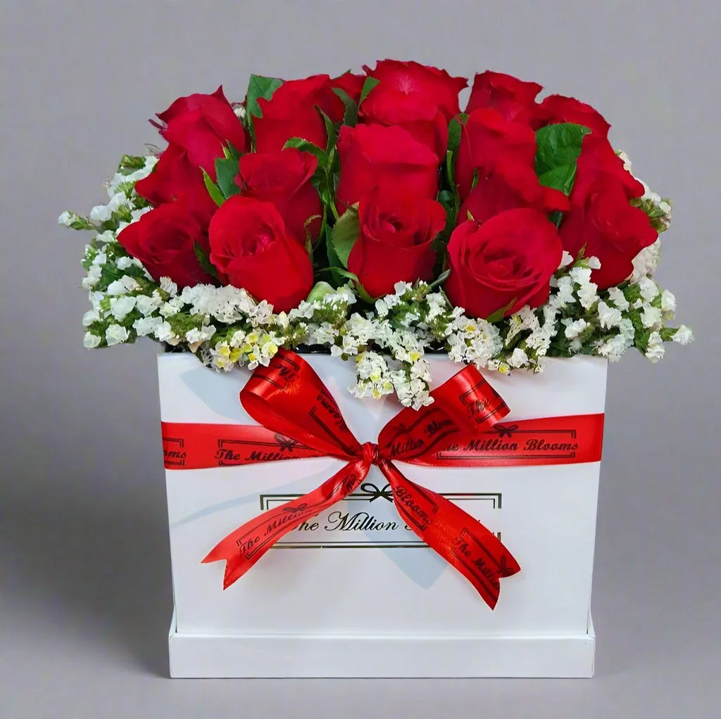 Elegant red roses in a white box with fresh white and green fillers, perfect for any special occasion. A beautiful display of love and sophistication.