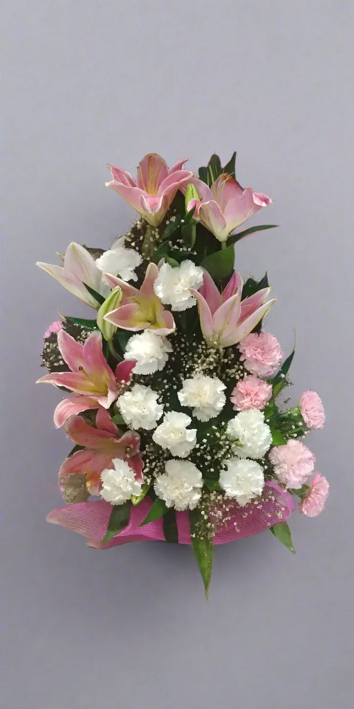 Delight in the timeless beauty of lilies and white carnations. A perfect blend of elegance and charm for every special occasion.